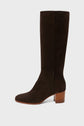 A single knee-high, dark brown suede boot with a rounded toe and a medium-height, stacked wooden heel, viewed from the side against a plain white background. These bottes en cuir velours fabriquées en Italie are the perfect addition to any bottes femme collection.