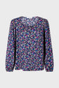 Long-sleeved blouse with a round neckline, featuring a colorful floral pattern on a dark background. The fabric appears lightweight with gathered cuffs and a buttoned front.