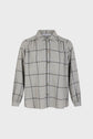 A long-sleeve, button-up shirt with a gray base and black windowpane check pattern. It has a collar, gathered shoulders, and cuffs on the sleeves.