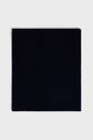 A square piece of dark navy blue fabric, reminiscent of a luxurious écharpe cachemire, is laid flat on a light gray background.
