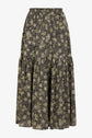 A long, flowy skirt with a black background and an all-over floral pattern in green and cream colors. The skirt has a gathered section below the knee, adding volume.