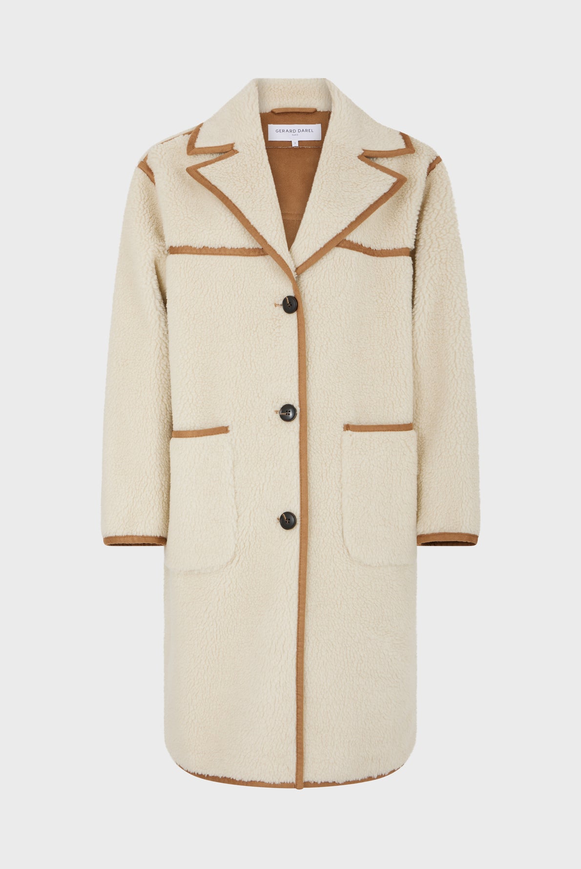 A long cream shearling coat with brown trim, three front buttons, two large front pockets, and a notched collar, this manteau hiver femme offers both warmth and vintage style, displayed on a plain white background.