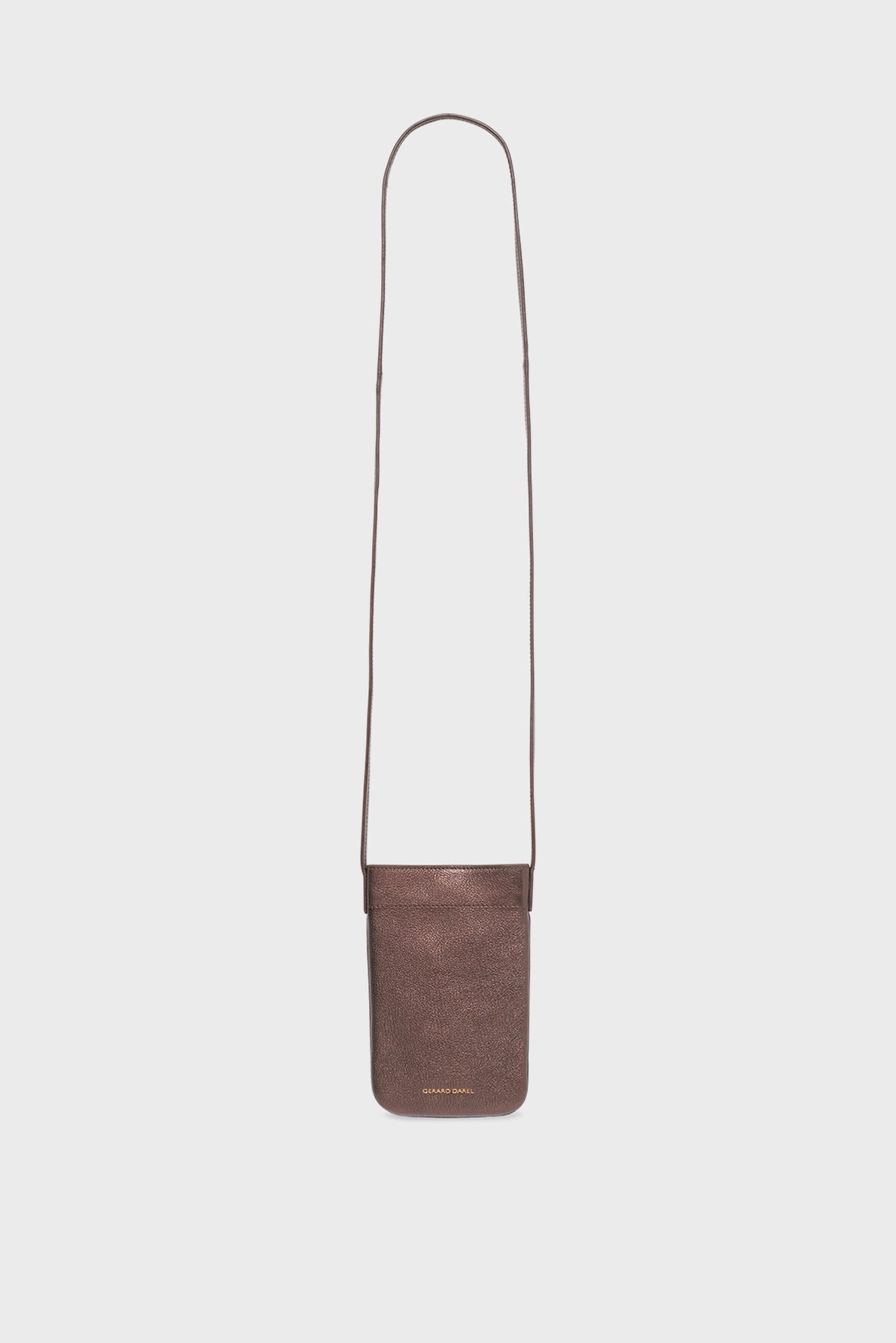 Small brown leather crossbody bag with a long, thin strap and a rectangular shape. This sac bandoulière femme features subtle texture and minimal gold text near the bottom, making it an accessoire tendance for any outfit. The background is plain white.