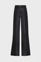 High-waisted black denim flared jeans with a striking denim bicolore effect, featuring wide panels of lighter and darker black, front pockets, and button details at the waist. These jean flare trousers offer a modern twist on a classic silhouette.