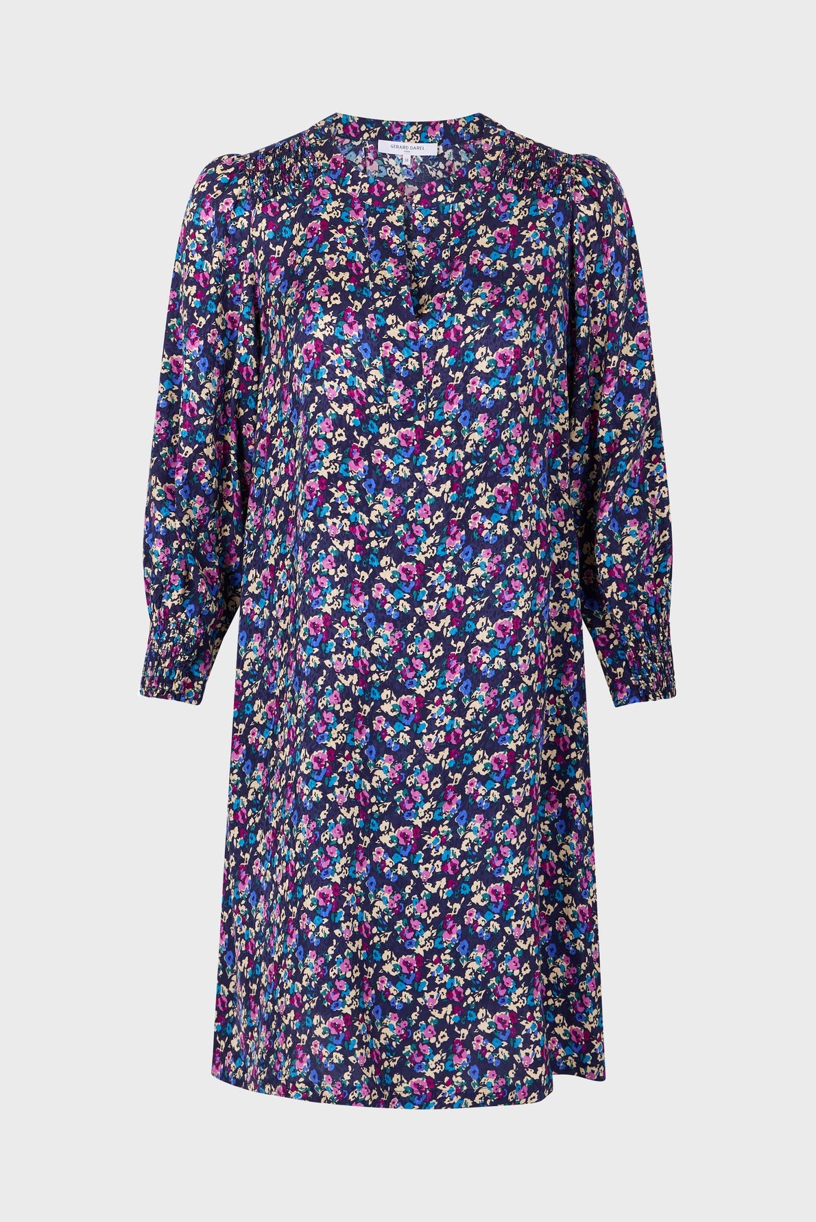 A knee-length, long-sleeve robe courte with a bright motif floral in pink, purple, and white on a dark blue background, featuring a round neckline and slightly gathered sleeves.