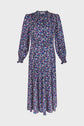 A long-sleeved, robe midi dress with a colorful motif floral print on a dark background, featuring a high neckline and gathered cuffs.