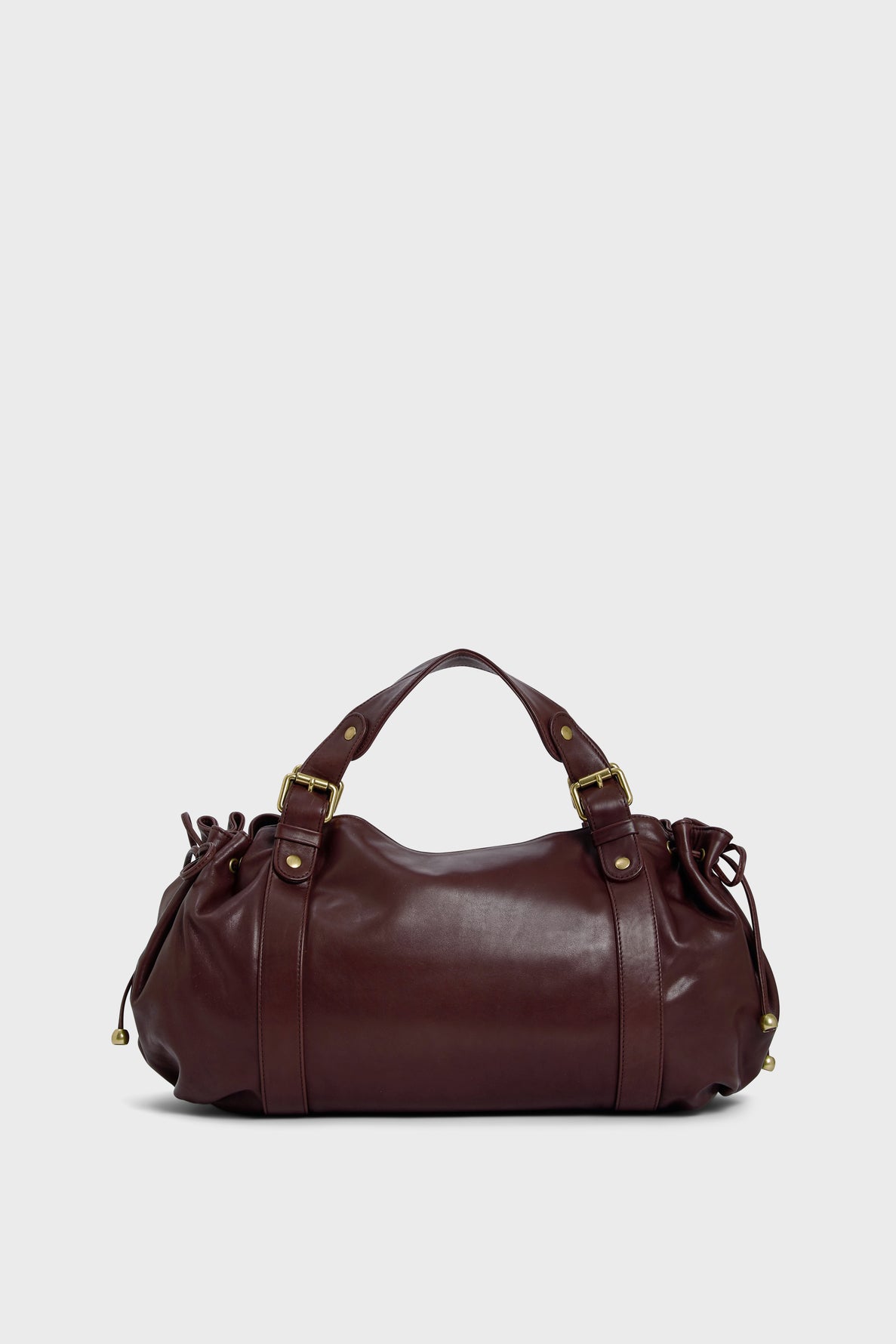 A dark brown maroquinerie Darel leather duffel bag with gold hardware, two handles, and side drawstring details crafted from cuir délicat, displayed against a light gray background.