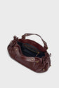 A maroon leather sac à main with gold hardware, ruched sides, and two handles. The bag is open, showing a black fabric-lined interior with a zippered pocket—a perfect example of maroquinerie Darel crafted from cuir délicat.