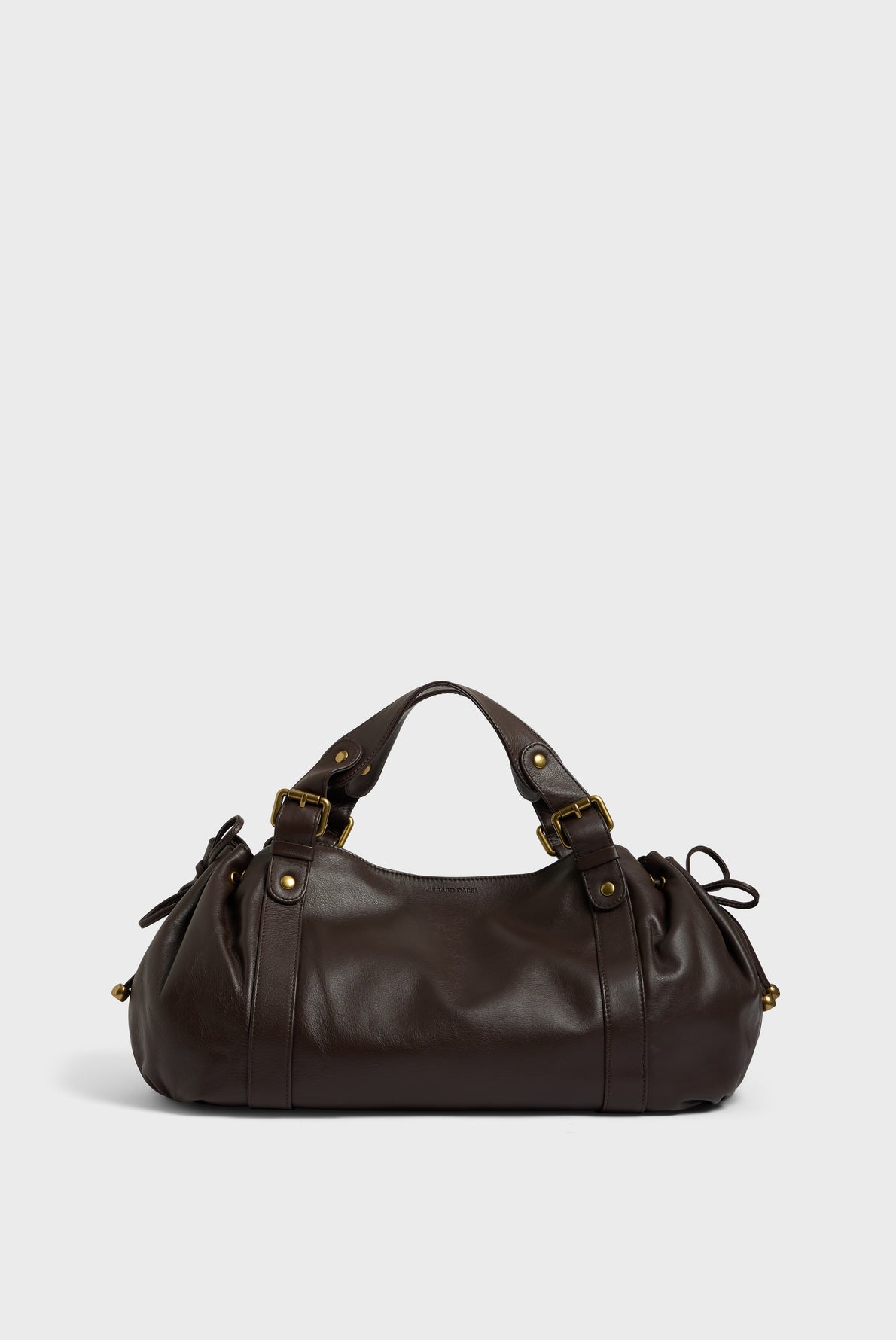 Dark brown sac à main in cuir délicat with gold hardware, double handles, and drawstring side details, placed against a plain light background—a refined piece of maroquinerie Darel craftsmanship.