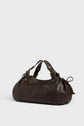 A dark brown cuir délicat leather sac à main with two short handles, gold hardware, and a gathered design at the ends, placed on a plain light background—a refined piece of maroquinerie Darel craftsmanship.