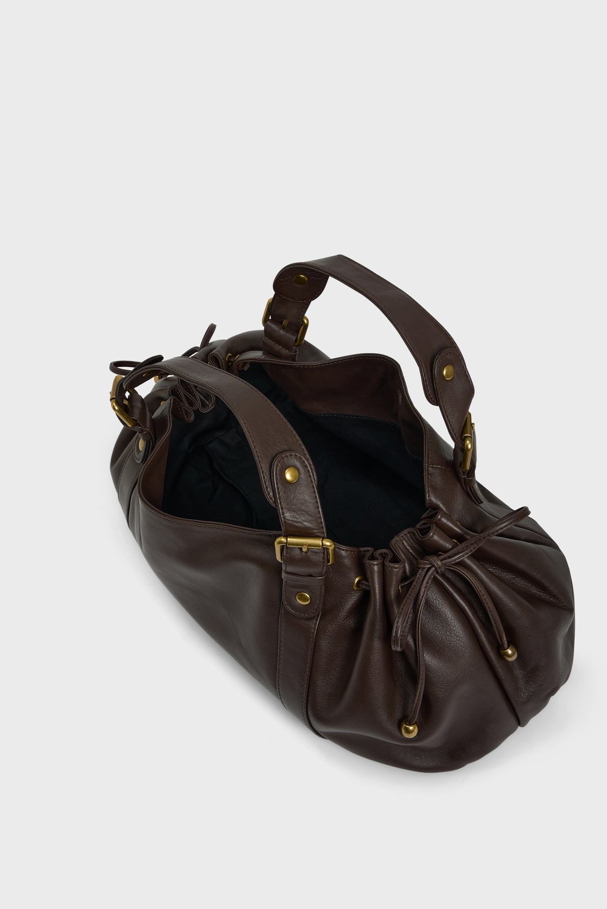 A dark brown cuir délicat leather sac à main with gold-tone hardware, two handles, and a partially open top revealing a black fabric interior—an elegant example of maroquinerie Darel craftsmanship.