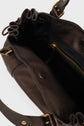 Open brown leather sac à main with gold hardware, showing a spacious interior, black fabric lining, a zippered pocket, and magnetic snap closure on the inside. Expertly crafted in maroquinerie Darel style with supple cuir de chèvre for timeless elegance.
