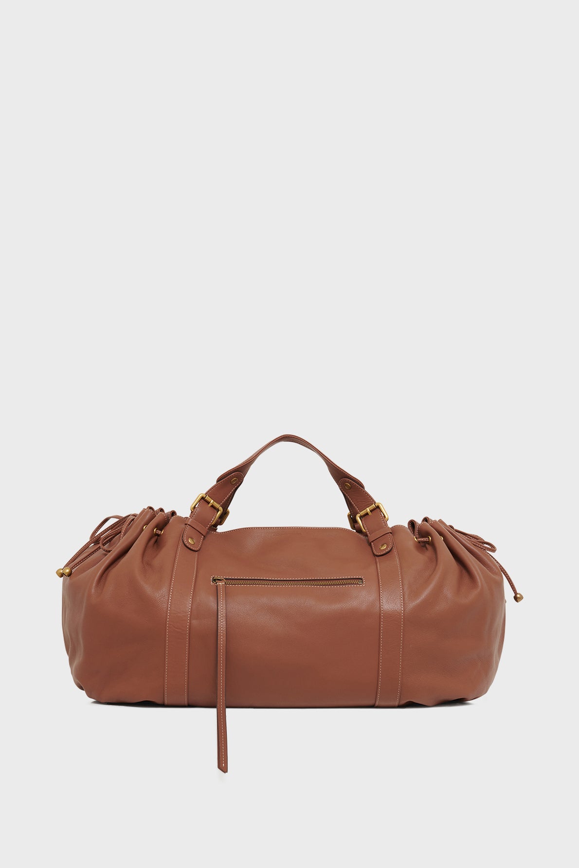 Brown leather duffel bag crafted from cuir délicat with a top handle, gold hardware, front zipper pocket, and drawstring details on each side—perfect as a sac à main 72h—shown against a plain white background.