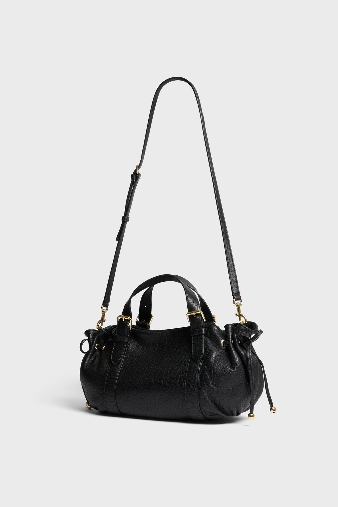 A black sac à main cuir with gold hardware, two short handles, and a long adjustable shoulder strap crafted from luxurious cuir bubble, displayed against a plain light gray background.