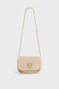A small beige besace en tricot de laine, crocheted by hand with a gold chain strap and a gold clasp on the front, is displayed against a plain white background.