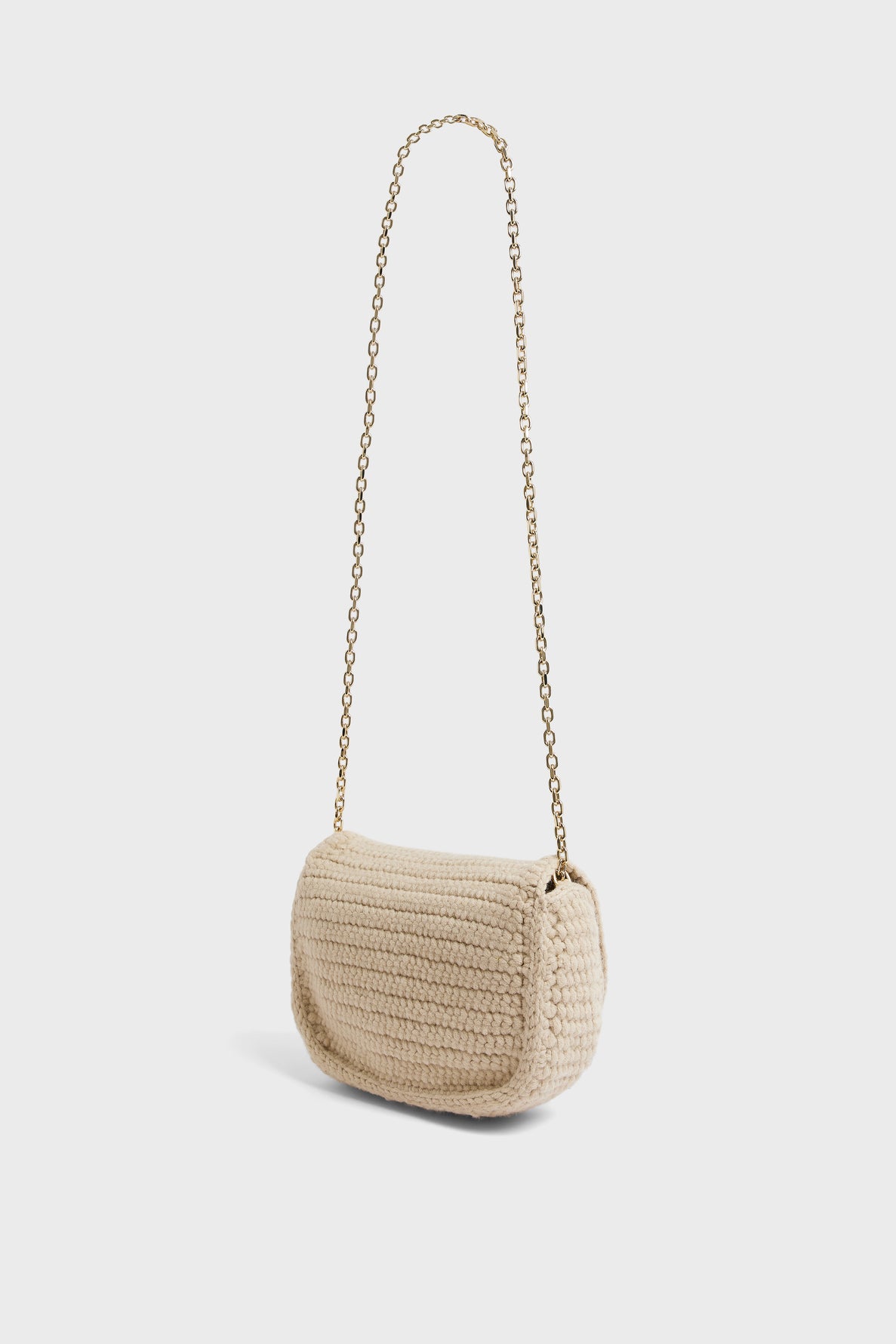 A small, beige besace en tricot de laine, crocheted with care and featuring a long gold chain strap, displayed against a plain white background.
