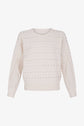 A cream-colored knit sweater featuring a crew neck, long sleeves, and small silver studs arranged in horizontal rows across the entire garment.
