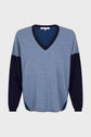 A blue V-neck sweater with dark navy accents on the collar, sleeves, and sides. The sweater has long sleeves and a relaxed fit.