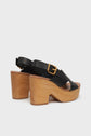 A pair of black leather sandales compensées with chunky light semelle en bois heels and gold buckles, shown from the back and side on a plain white background.
