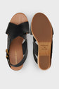 A pair of black leather sandals with crisscross straps, a tan footbed, and a brown sole. Featuring subtle cuir marron accents, these sandales compensées offer elevated style and comfort. One sandal is shown from the top, the other from the bottom, displaying the size and brand details.