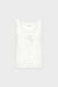 Sleeveless white blouse with zigzag cut edges on the neckline and hem, and a small bow tie detail at the front center. The blouse has a relaxed fit and is displayed against a plain light background.