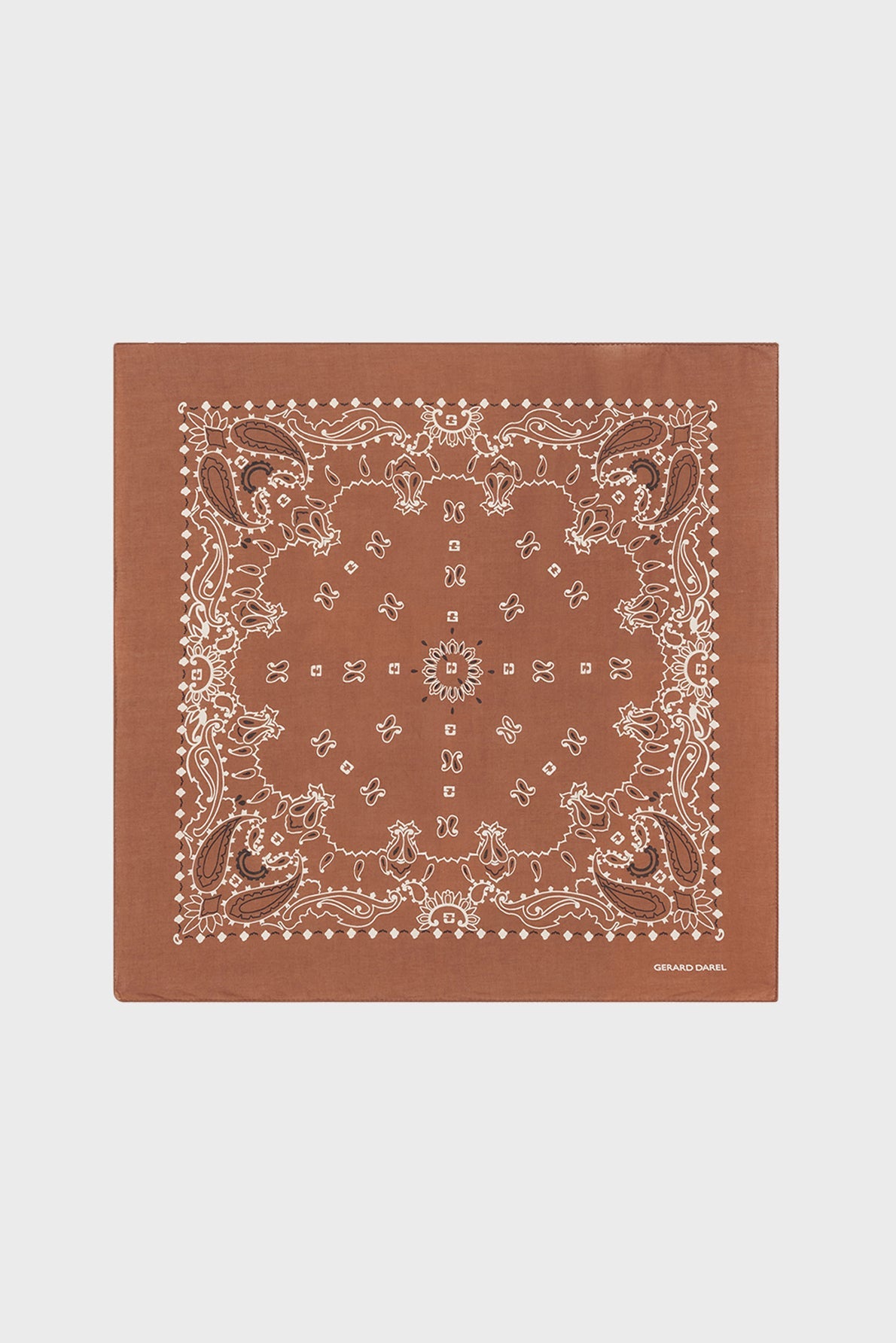 A brown square bandana carré in soft bandana coton, adorned with a classic white paisley and floral pattern, features intricate borders and small motifs géométriques, displayed on a plain light background.