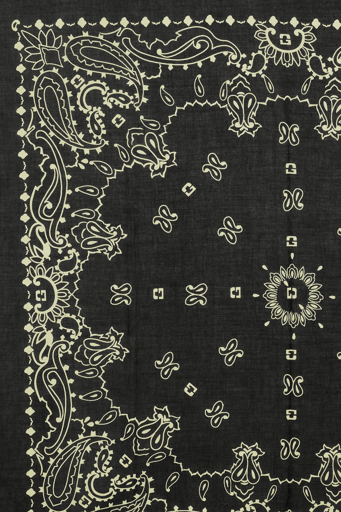 Black bandana with intricate white paisley, floral, and geometric patterns along the border and scattered small shapes in the center. Made from soft bandana coton, the design is symmetrical and decorative, featuring classic bandana motifs géométriques for a timeless vintage look.