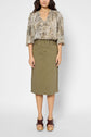 Woman wearing a snakeskin-print blouse, olive green knee-length skirt with frayed sides, and brown platform sandals, standing against a plain white background.
