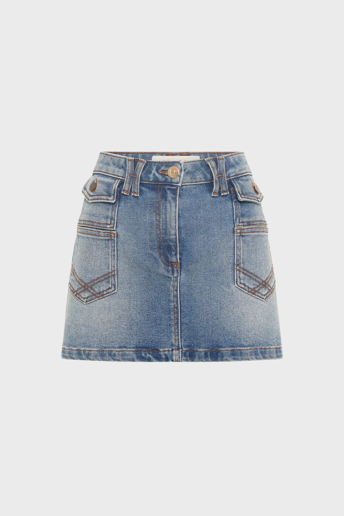 Blue denim mini skirt with front button and zip, two side pockets with flaps and buttons, and two stitched front pockets. This mini-jupe en denim from the collection Studio features visible seams and a slightly faded wash.