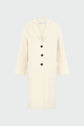A long, cream-colored manteau droit femme with three black buttons, two large front pockets, and a notched collar, displayed against a light gray background.
