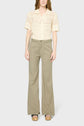 A person wearing a short-sleeve, cream crochet top with a collar, wide-leg khaki pants, and platform sandals stands facing forward against a plain background.