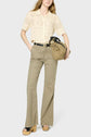 Person wearing a cream short-sleeve knit shirt tucked into high-waisted beige wide-leg pants, black belt, tan platform sandals, and holding a tan handbag.