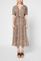A person wearing a mid-length, short-sleeve dress in voile de coton with an imprimé léopard and a V-neckline, paired with brown platform sandals, standing against a plain light background.