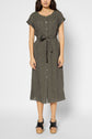 Woman wearing a short-sleeved, button-front, olive green midi dress with a waist tie, standing against a plain background. She has black platform sandals and is facing forward with arms by her sides.