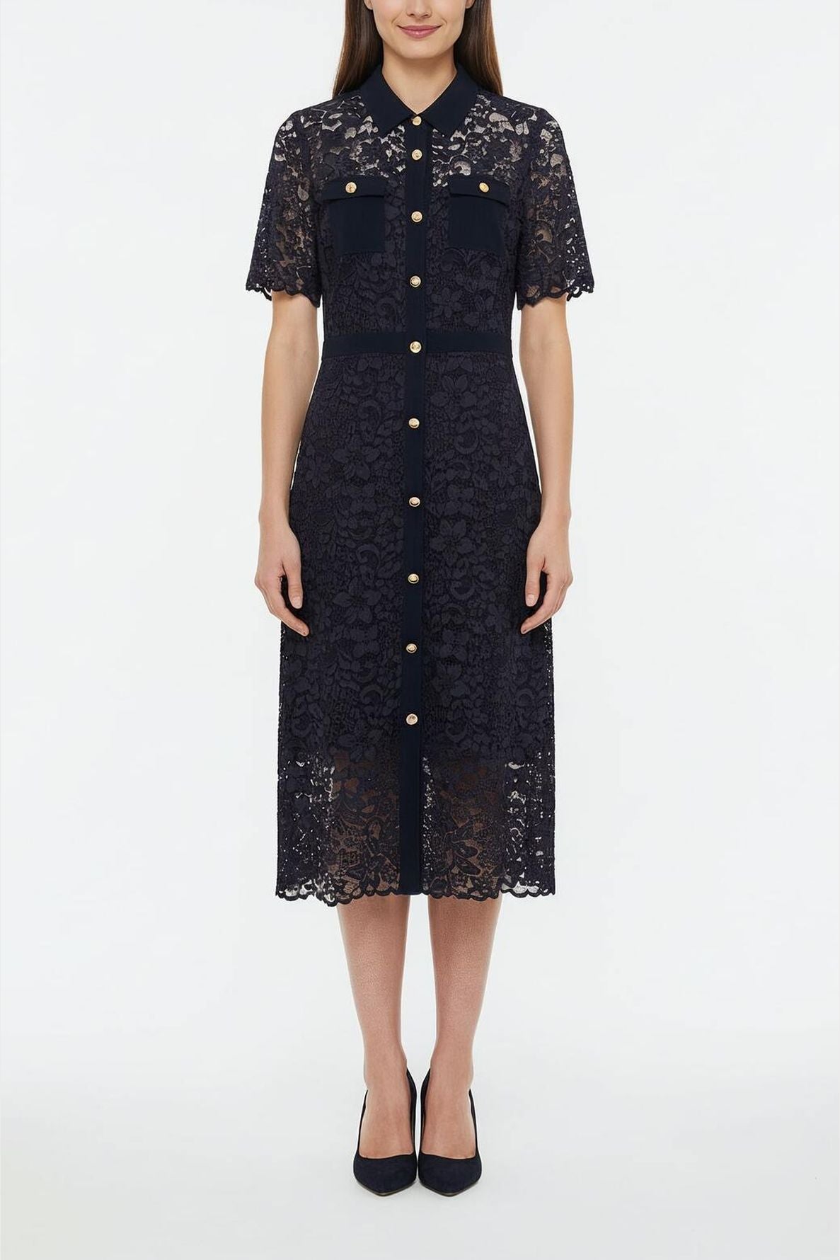 Woman standing in a navy blue, button-down robe en dentelle with short sleeves, col chemise, front pockets, and black heels, against a plain white background.