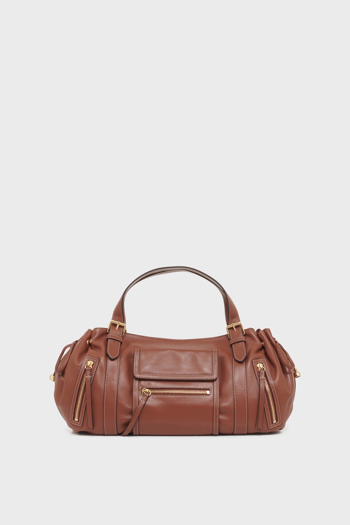Brown leather sac à main with two handles, front zippered pocket, and side poches zippées compartments, displayed against a plain white background.
