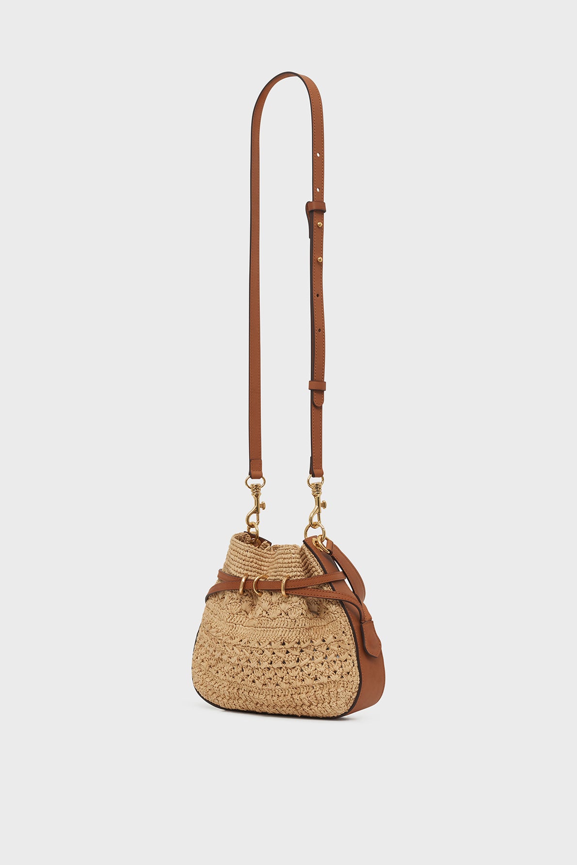 A small sac seau mini crossbody bag, expertly crafted with cuir et raphia, featuring gold-tone hardware, an adjustable strap, and decorative leather accents—a true testament to savoir-faire artisanal—displayed on a plain white background.