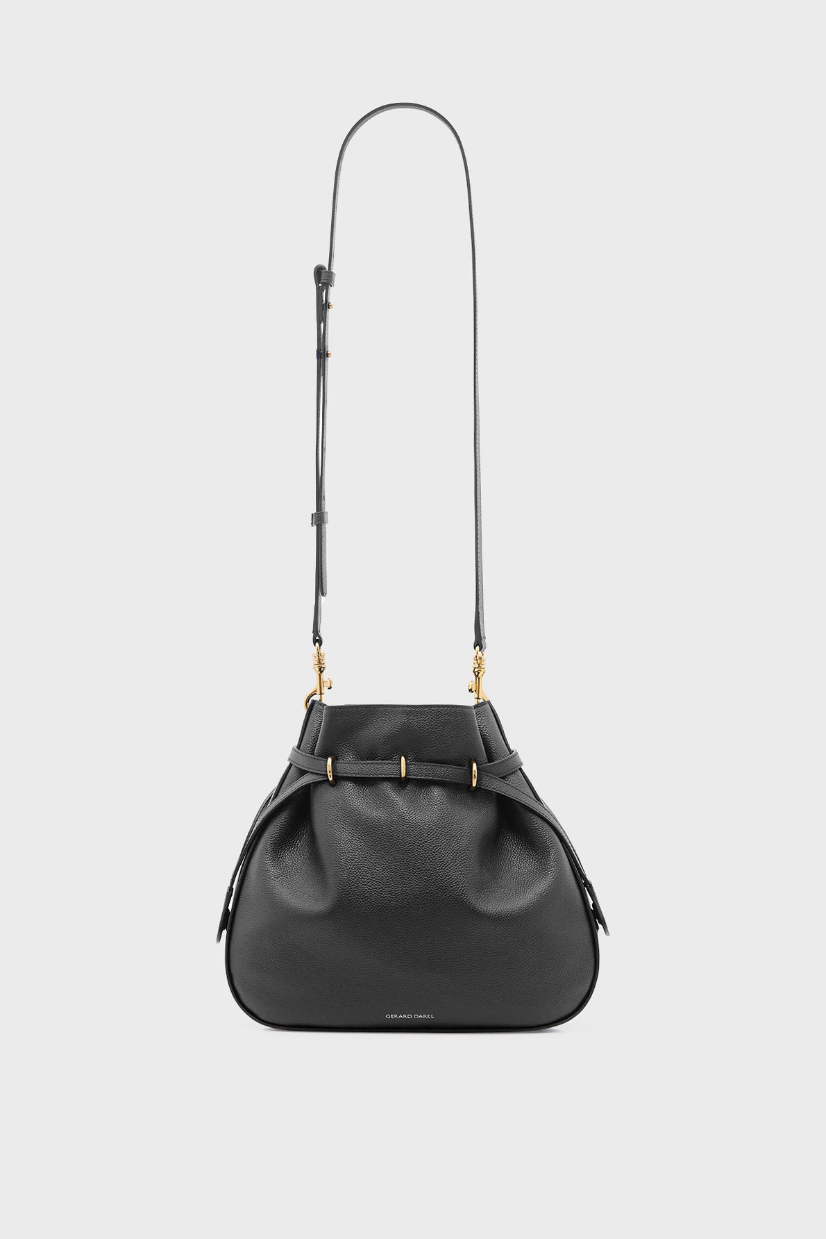 Black leather shoulder bag with a structured, rounded shape crafted from cuir grainé, featuring gold hardware, an adjustable long strap, and subtle embossed branding on the front—an embodiment of élégance sophistiquée set against a plain white background.