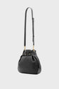 A black cuir grainé leather shoulder bag with gold hardware and an adjustable strap, set against a plain light grey background. The sac seau style features a soft, rounded shape with subtle pleating near the top, epitomizing une élégance sophistiquée.