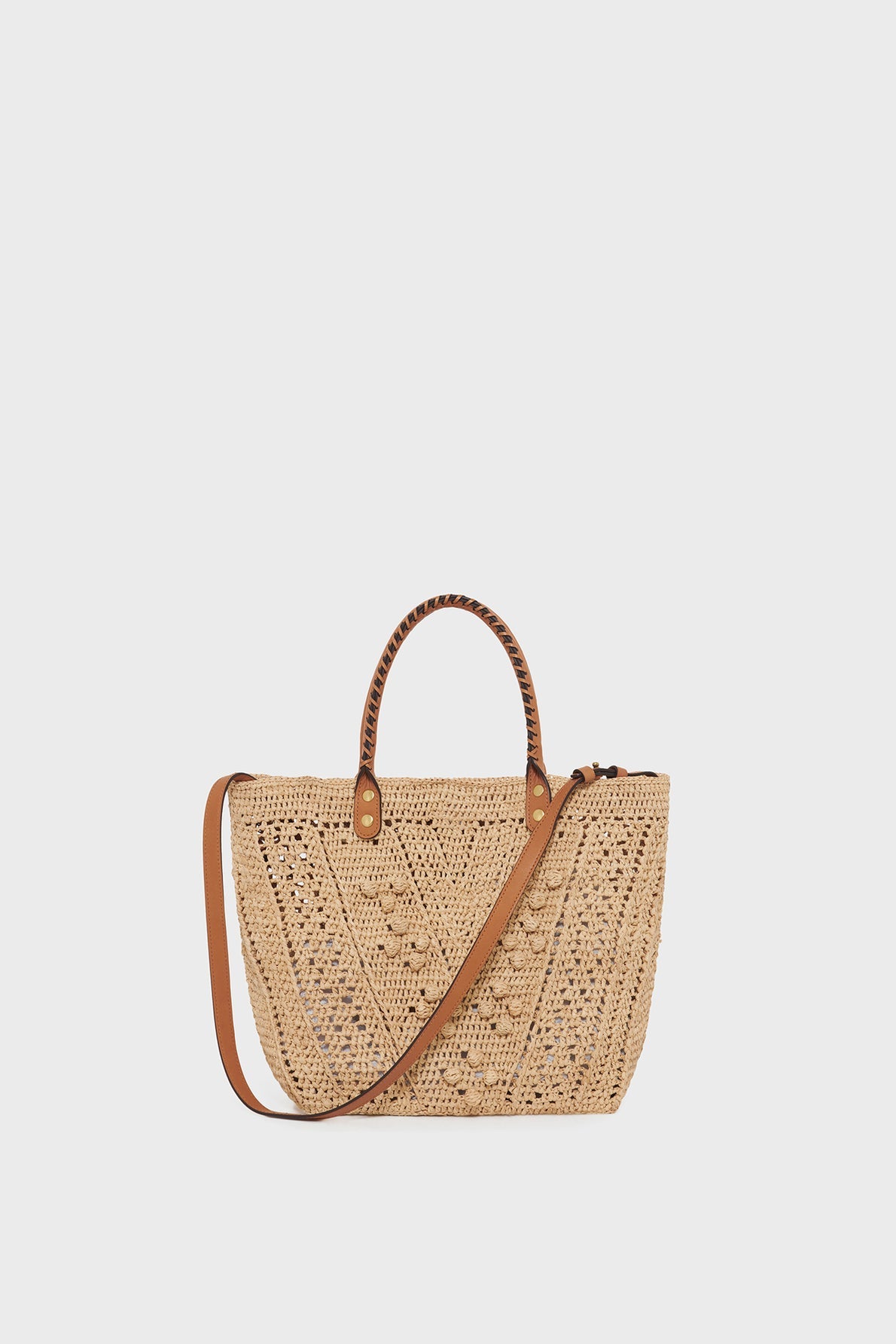 Beige woven straw tote bag with brown leather handles and a matching adjustable shoulder strap, beautifully showcasing savoir-faire artisanal craftsmanship—an elegant sac à main raphia displayed on a plain light background.