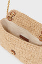 A close-up of an open sac raphia handbag with a light fabric lining, a small inner pocket, and an elegant bandoulière chaîne showcases exquisite savoir-faire artisanal craftsmanship.