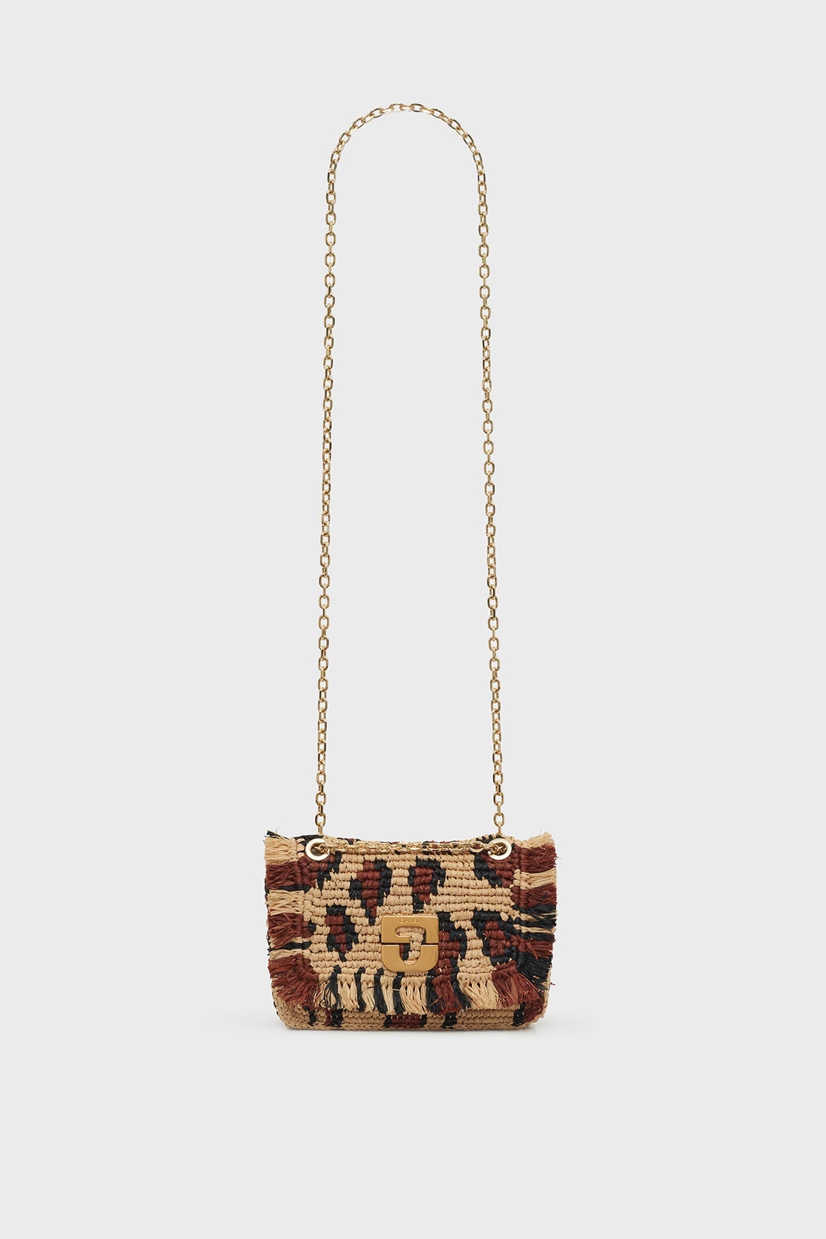 Woven sac bandoulière with a long gold chain strap, featuring a brown, black, and beige tribal pattern and fringe detailing on the sides, crafted with savoir-faire artisanal skill and set against a plain white background.