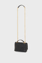A small black sac créateur, this quilted leather handbag features a gold chain shoulder strap and a short top handle, elegantly displayed on a plain white background.