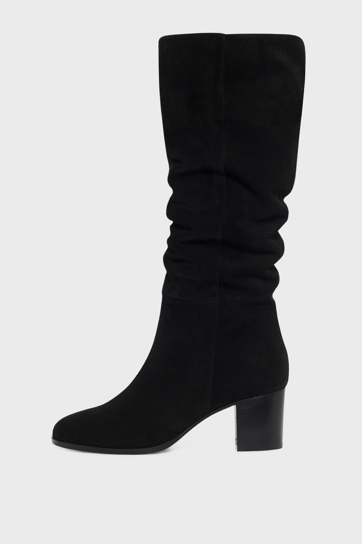 A black suede knee-high boot with a round toe, slightly slouched shaft, and a low block heel, displayed against a plain light gray background.