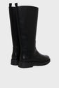 A pair of tall, black botte cuir femme with flat soles and pull tabs at the back, positioned on a light gray background.