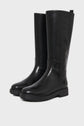 A pair of shiny black knee-high leather boots with a low heel and rubber sole, these bottes cuir femme affichent une allure élégante et moderne, parfaites pour toutes les occasions. Displayed on a white background.