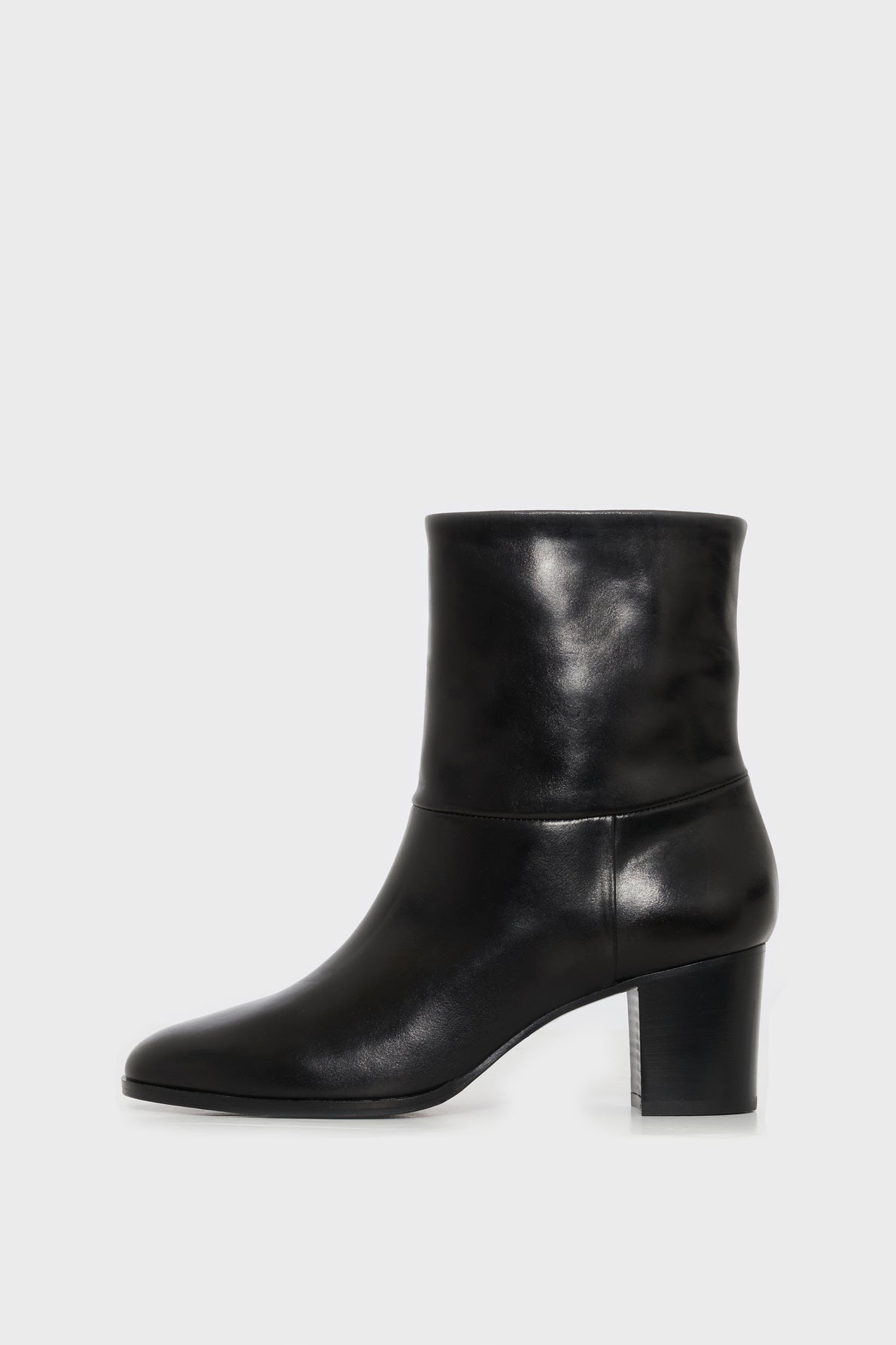 A pair of bottines mi hautes en cuir noir, fabriquées en Italie, featuring a rounded toe and a mid-height block heel, shown in profile against a plain white background.