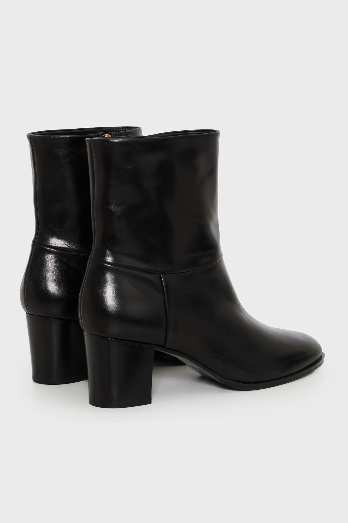 A pair of bottines mi hautes en cuir noir, fabriquées en Italie, with block heels is shown from the back and side on a plain light background.