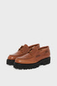Brown leather lace-up shoes with thick black semelle crantée (lug soles), displayed against a plain white background.