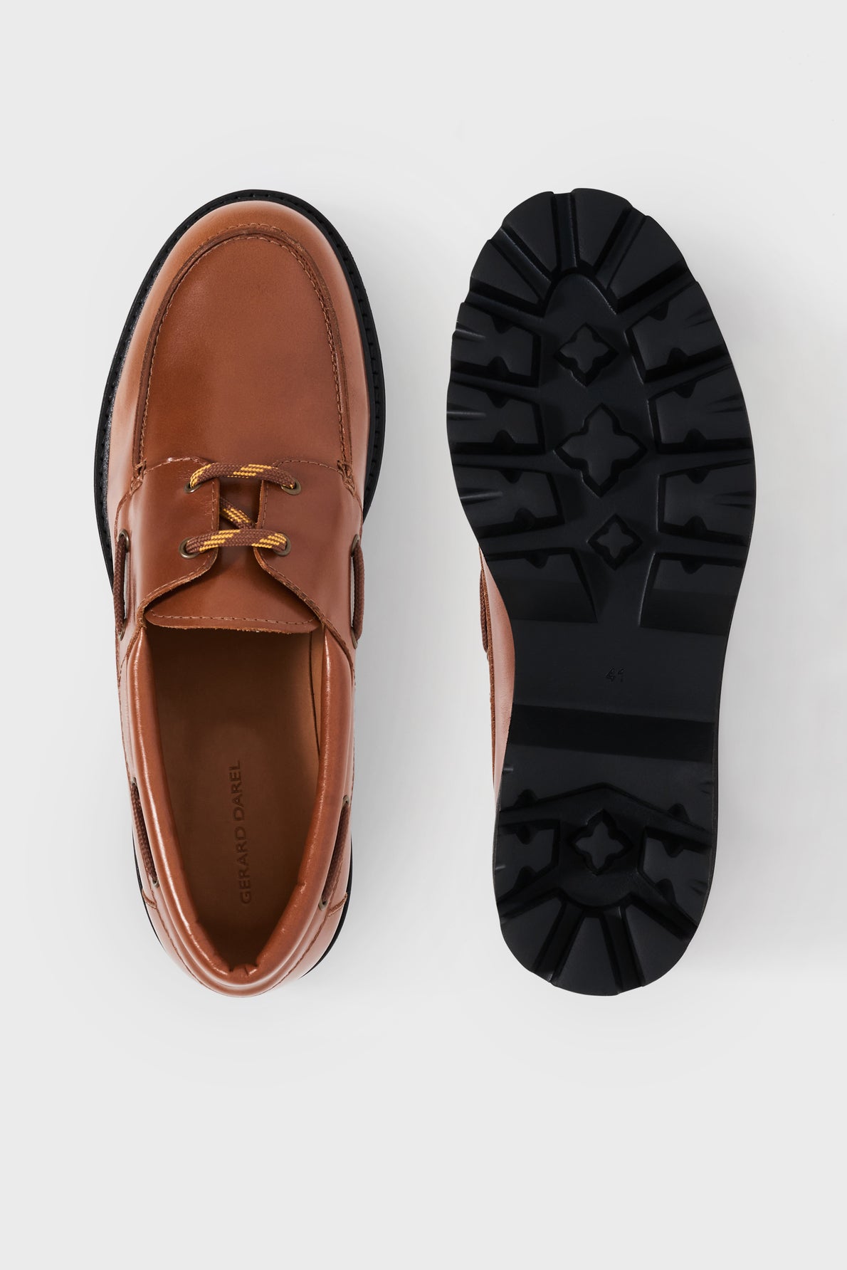 A pair of brown cuir uni leather shoes, one shown from the top displaying laces, and the other from the bottom showing a black semelle crantée tread sole, on a white background.